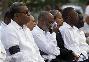 Haiti's President Rene Preval, second from left, wipes his tears as he attends a national day of mourning ceremony in Port-au-Prince, Friday, Feb. 12, 2010.